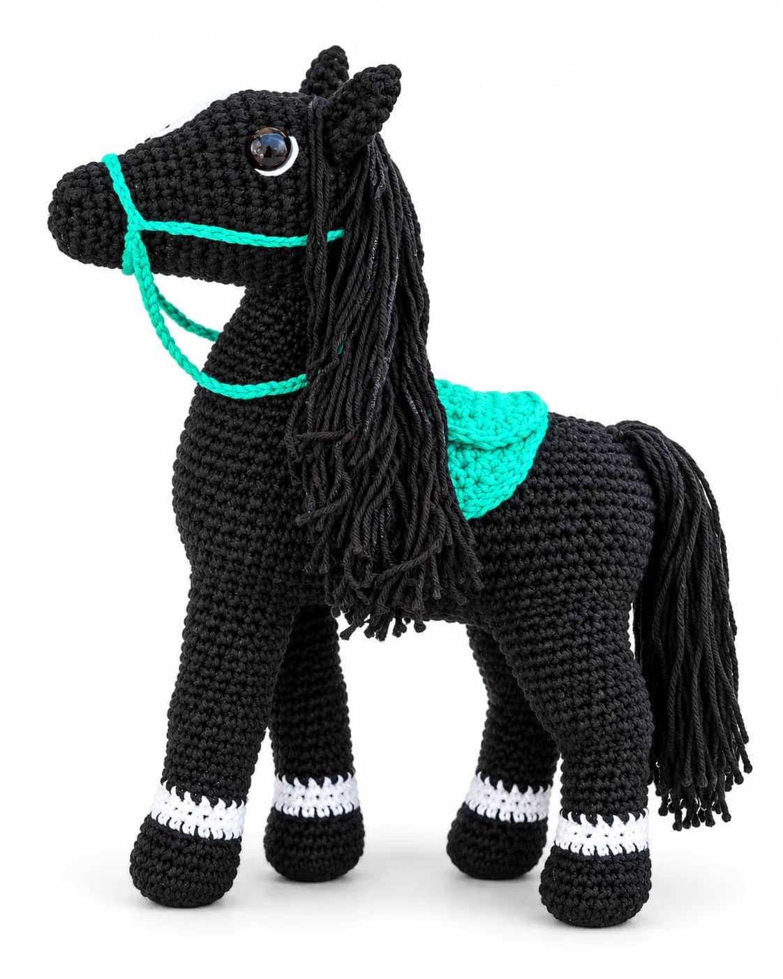 Cavalo amigurumi preto com sela e cabresto verde-água em fundo claro